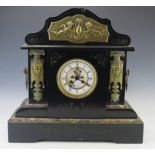 A large late Victorian polished slate mantel clock of arched outline, with applied gilt metal female