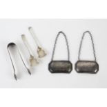 A mixed collection of silverwares, includes sugar tongs, salt spoons, spirit labels, various