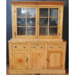 A 19th century pine dresser, the associated top with moulded cornice, above a pair of glazed panel