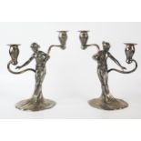 WMF, a pair of Jugendstil silver plated figural twin branch candelabra, the sconces on sinuous swept