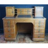 A late Victorian/Edwardian oak twin pedestal writing desk, the superstructure with sunken centre