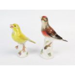 Two Meissen porcelain finches, perched on tree stumps, 13cm and 12cm high. Both with damaged beaks.