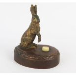 A cold painted bronze electric switch, modelled in the form of a hare, mounted on an oval base, with