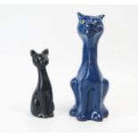 A Torquay pottery model of a winking cat, incised "Good Luck", to a blue ground, 16.5cm high,