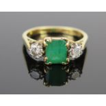 A Modern 18ct Gold, Emerald and Diamond Three Stone Ring, c. 6.9x5.8mm emerald and 4mm brilliant