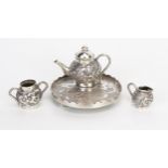 A Chinese silver miniature tea service and tray, with prunus decoration, total weight of silver