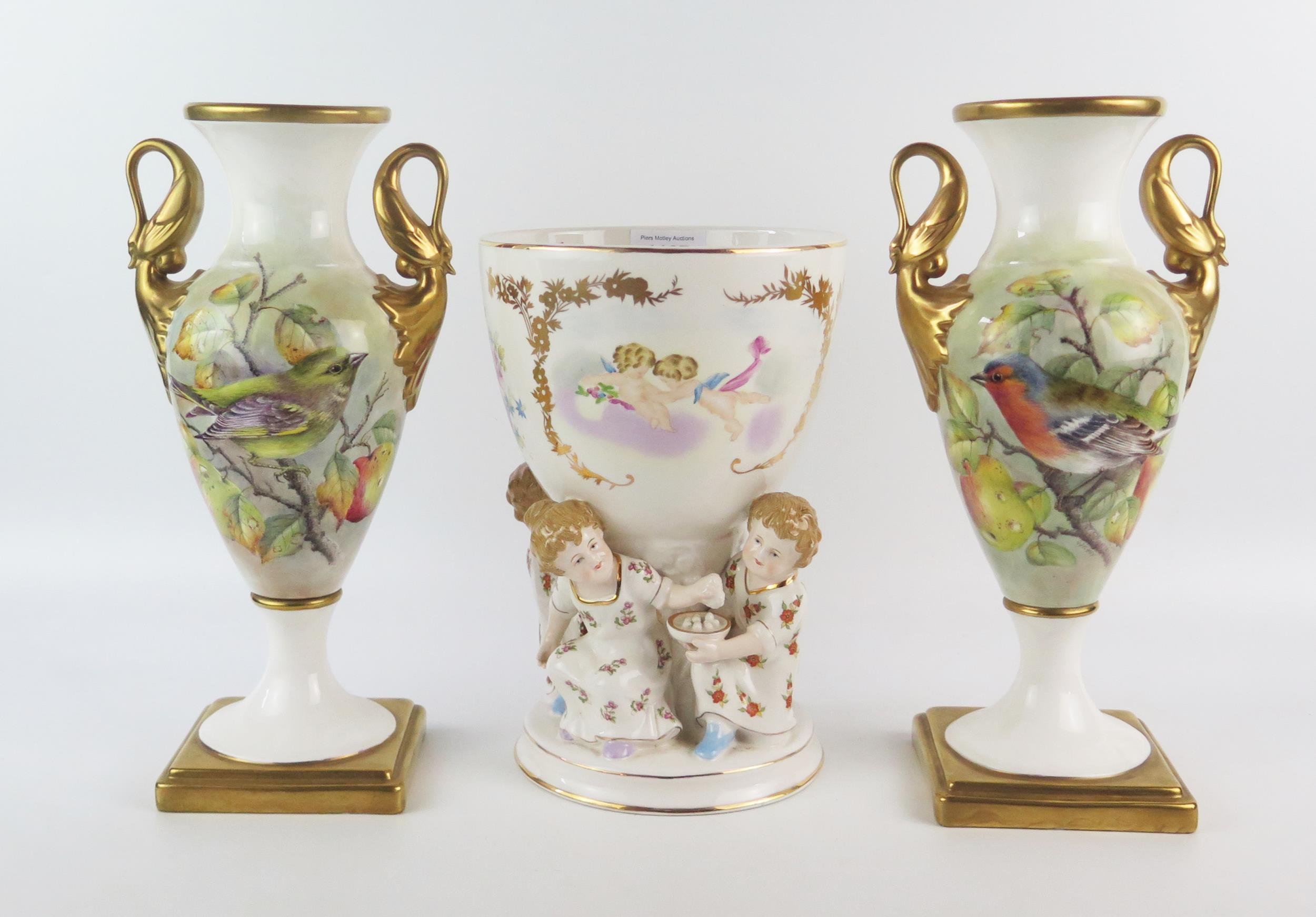 A pair of G Delaney porcelain twin handled vases, of ovoid form, the gilded handles modelled as