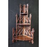 A Gothic revival mahogany corner shelf, with pierced spire and fleur d'lys decorated back having