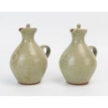 A pair of Bernard Leach pottery oil and vinegar jars and covers, impressed marks, 11cm high. A/F