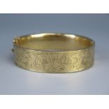 A 9ct Gold Hinged Bangle with chased foliate decoration, 20.7g