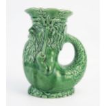 A Dartmouth Pottery gurgling jug modelled as King Neptune, holding tridents, in green glaze, 18.