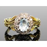 An Aqua Marine and Diamond Cluster Ring in an unmarked 18ct gold setting, c. 7x5,1mm central stone