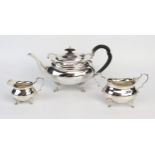 A matched silver three-piece tea service, of barge-shaped outline, with wavy edge border, raised