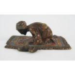An Austrian cold painted model of an Arab praying on a prayer rug, unsigned, 6.5cm long.