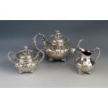 A silver plated three-piece tea service, of squat circular form, with bird finial and floral