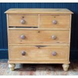 A Victorian pine rectangular chest containing two short and two long drawers, raised on turned legs,