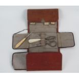 A leather sewing pouch containing assorted sized needles, hooks and scissors