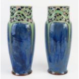 A pair of Royal Doulton pottery vases of ovoid form with cylindrical necks and sinuous decoration,