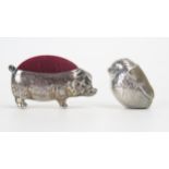 A novelty silver pin cushion in the form of a pig, all marks worn, 4.5cm long, together with another