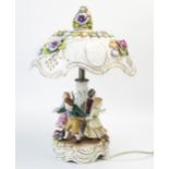 A Dresden porcelain table lamp, with pierced and floral decorated shade, having a central stem