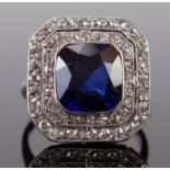 An Art Deco Synthetic Sapphire and Diamond Ring in an unmarked white metal setting, the central