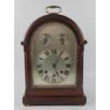 A mahogany cased director's style bracket clock, with arched silvered Roman dial with regulation and