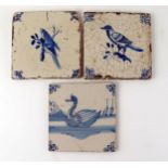 Three Dutch Delft tiles, each depicting a bird, with ox-head corner motifs, each 13 x 13cm