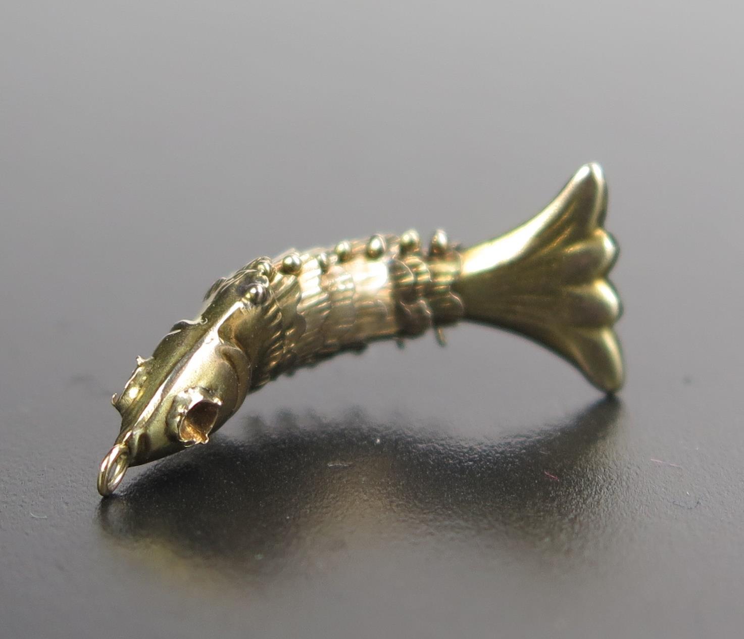 A 14K Gold Stamped Charm in the form of an articulated fish, 1.1g - Image 2 of 2