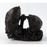 A Japanese carved and stained hardwood netsuke in the form of two leaping carp, unsigned, 5cm wide.