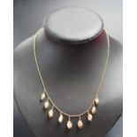 A 9ct Gold and untested Pearl Fringe Necklace with nine pearls suspended in decorative cages, 17.25"