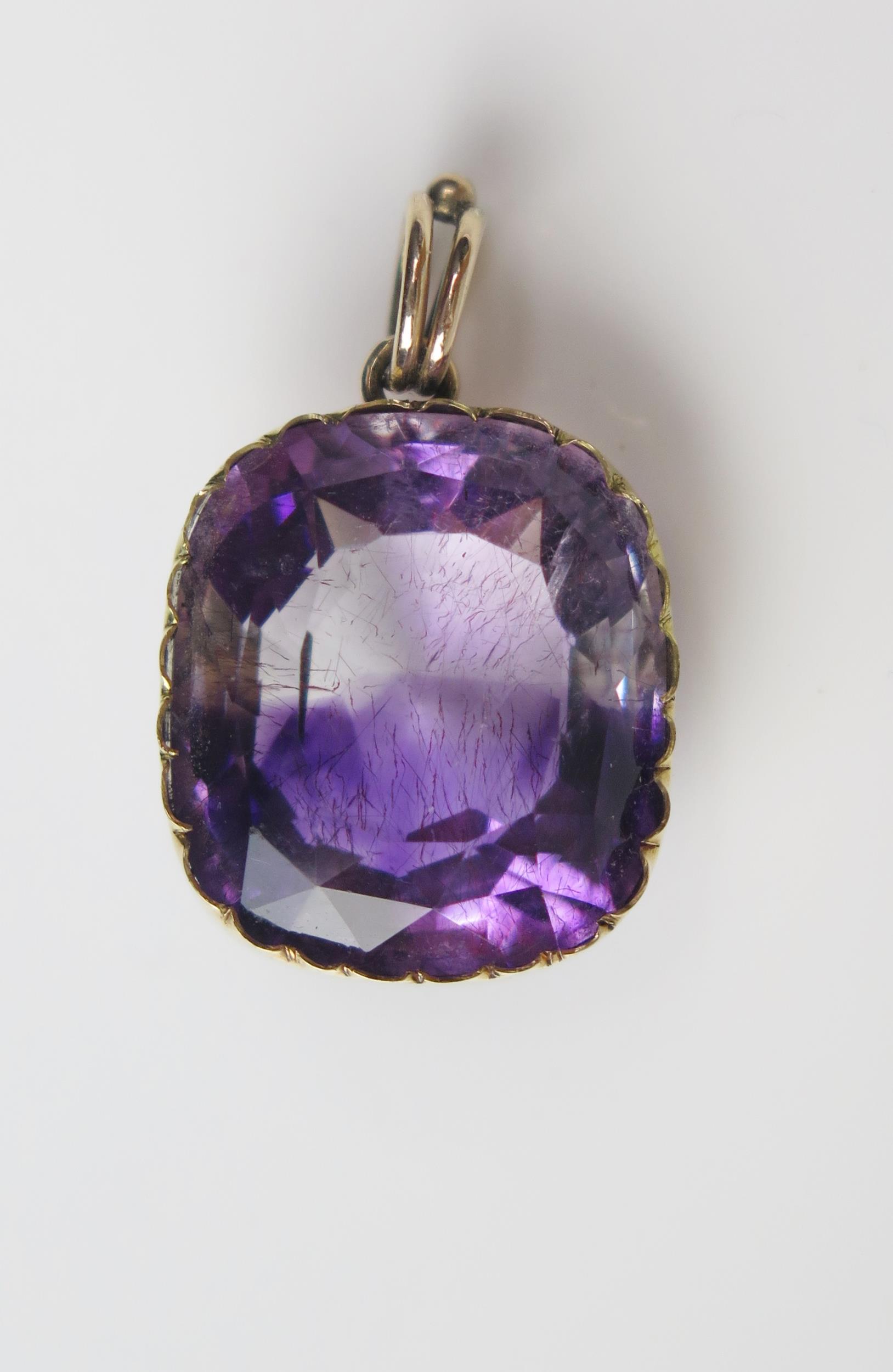 An Antique Amethyst Pendant in an unmarked gold setting, the 18.5x16.2mm stone with clear and purple