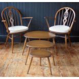 A pair of Ercol Fleur d'Lys Windsor chairs with arched back, swept arm supports and solid seat on