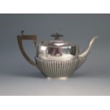 A George V silver bachelors oval teapot, maker Jones & Crompton, Birmingham, 1910, with half