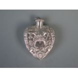 A silver scent bottle of heart-shaped outline, with embossed floral and shell decoration, 5.25cm