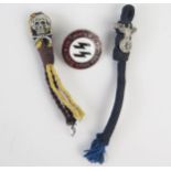 A replica SS police enamel badge, and two woven part hangers with totenkopf badge and another with