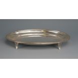 A George V silver oval teapot stand, maker's mark worn Chester, 1912, with reeded border, on four