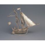 A Dutch silver model of a galleon with two crew members, mounted on a rocker base, 14cm long, 91gms,