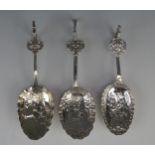 Three Dutch silver spoons, stamped marks, the bowls decorated with figures in village scenes, having