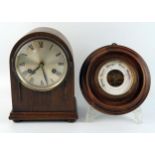 An oak cased mantel clock of arched outline, with 12cm silvered Roman dial, the movement striking to