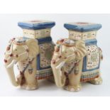 A pair of modern Chinese pottery jardiniÃ¨re stands in the form of elephants, with polychrome