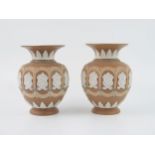 A pair of Royal Doulton Silicon pottery vases, of ovoid form, with panelled flowerhead decoration,