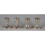 Two pairs of miniature silver desk candle sticks, of traditional design with filled circualr
