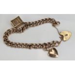 A 9ct Gold Curb Link Bracelet with 10 shilling note charm, heart shaped locket charm and damaged '