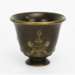 A bronze Buddhist temple wine cup, of conical form with vase low relief decoration, 4.75cm high.