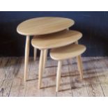 A Modern Ercol nest of three 'Pebble' style occasional tables, raised on turned legs.