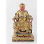 A late 19th century polychrome carved wooden figure of a seated emperor, with gilded decoration,