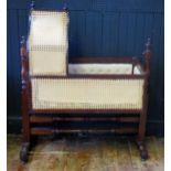 A 19th century child's mahogany swinging crib, with arched cane panelled hood and sides, suspended