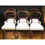 A set of six Victorian rosewood dining chairs, with hoop backs and stuff over seats raised on