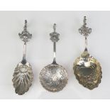 Three continental silver spoons with shell shaped bowls cartouche mounted stems, with figural