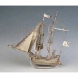 A Dutch silver model of a galleon with two crew members, mounted on a rocker base, 14cm long, 91gms,